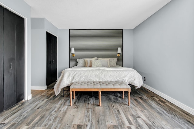 bedroom featuring baseboards and wood finished floors