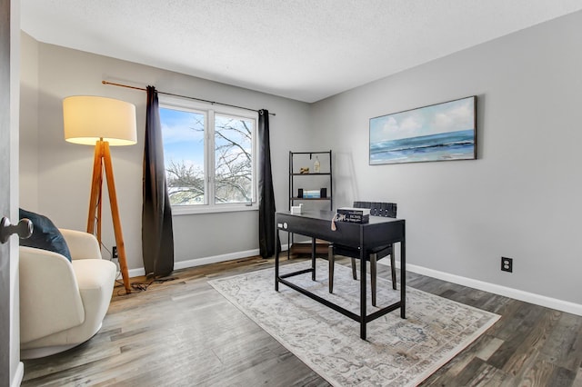 home office with baseboards, a textured ceiling, and wood finished floors