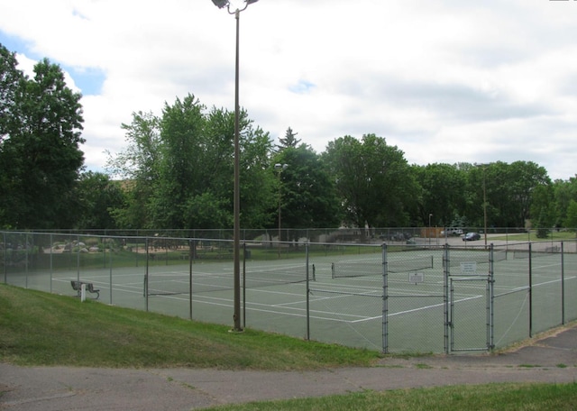 view of tennis court featuring fence and a gate