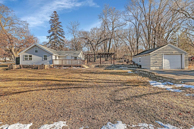 yard layered in snow with an outdoor structure, a garage, and a deck