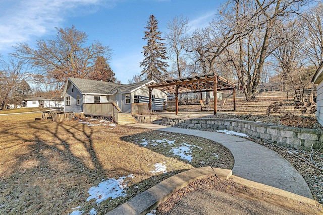 view of property's community with a pergola, a deck, and a lawn