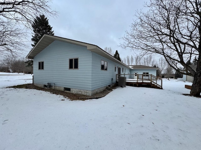 view of snow covered exterior with a deck and central air condition unit