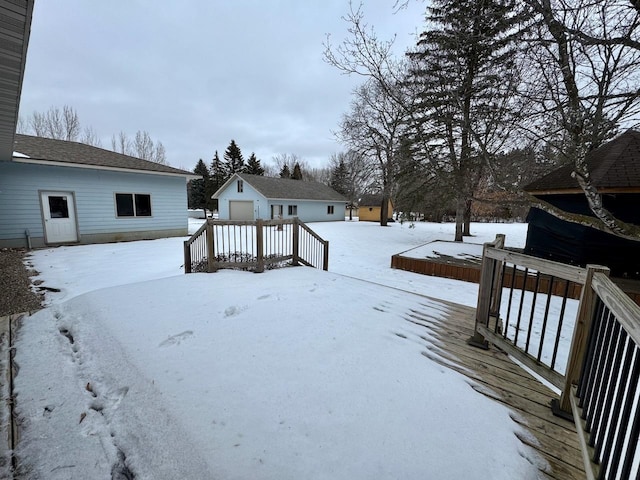 yard covered in snow featuring a garage and an outdoor structure