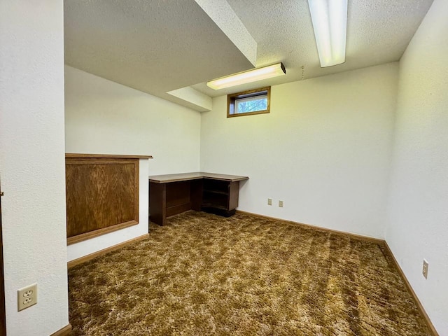 basement with dark colored carpet and a textured ceiling