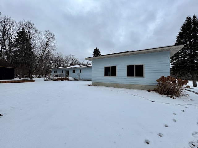 snow covered house featuring a wooden deck