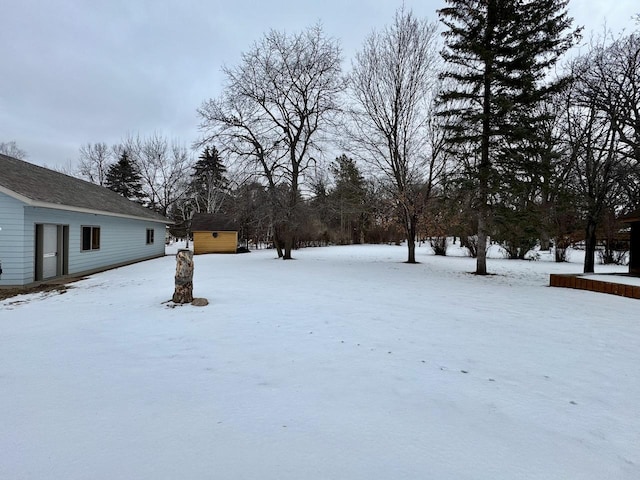 yard layered in snow with an outbuilding