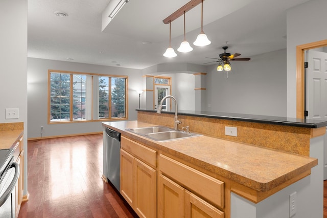 kitchen featuring dark wood-style flooring, decorative light fixtures, stainless steel appliances, light brown cabinets, and a sink