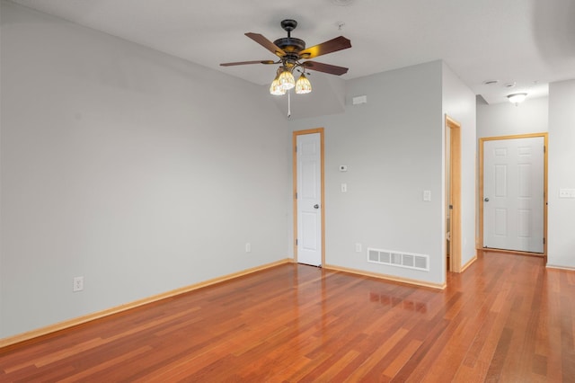 unfurnished room with a ceiling fan, baseboards, visible vents, and wood finished floors