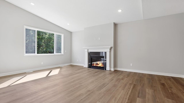 unfurnished living room featuring wood-type flooring and vaulted ceiling