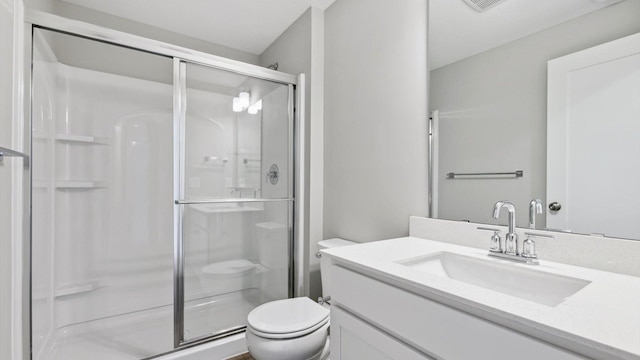 bathroom with vanity, toilet, and a shower with shower door