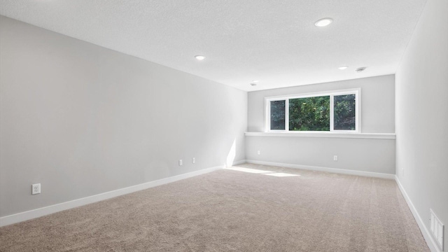 carpeted spare room featuring a textured ceiling