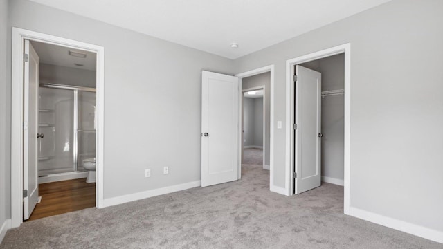 unfurnished bedroom with light carpet and connected bathroom