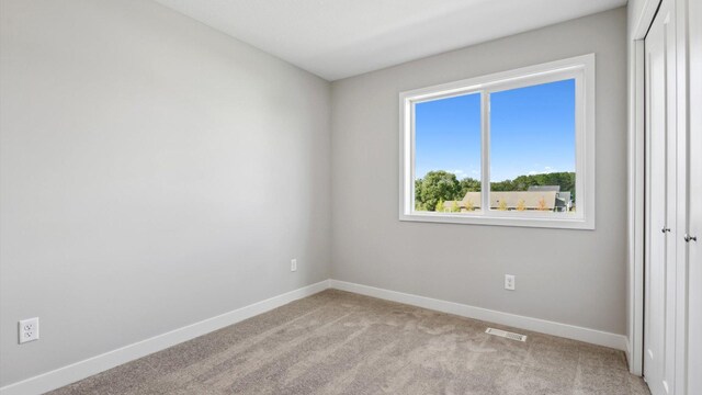 spare room featuring light carpet