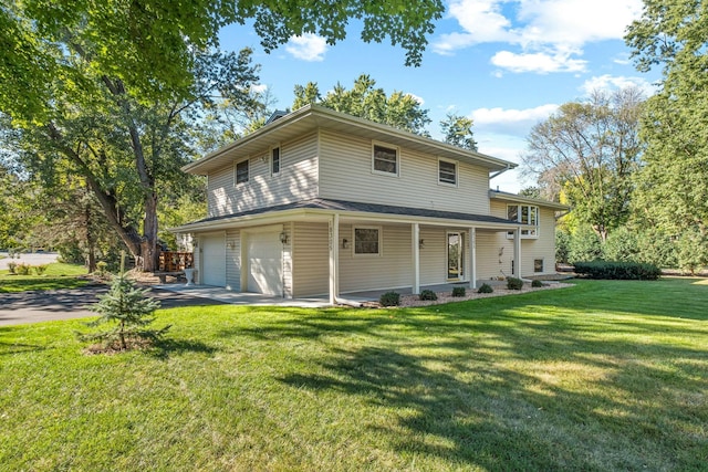 rear view of property featuring a garage, a yard, and covered porch