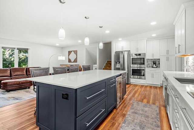 kitchen with pendant lighting, white cabinetry, a kitchen breakfast bar, a center island, and stainless steel appliances