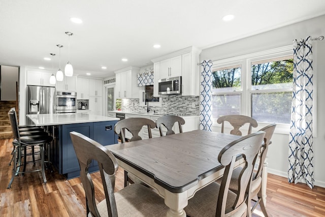 dining area with sink and light hardwood / wood-style flooring