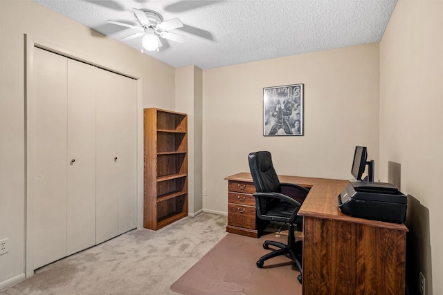 carpeted office space with ceiling fan and a textured ceiling