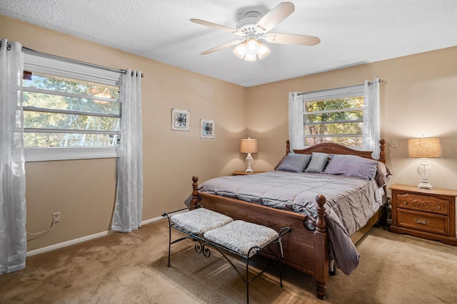 carpeted bedroom featuring ceiling fan and a textured ceiling