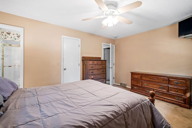 carpeted bedroom featuring ceiling fan and ensuite bath