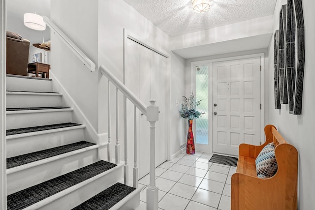 foyer featuring light tile patterned flooring and a textured ceiling