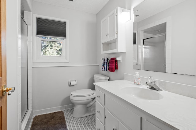 bathroom featuring toilet, a shower with shower door, a textured ceiling, vanity, and tile patterned flooring