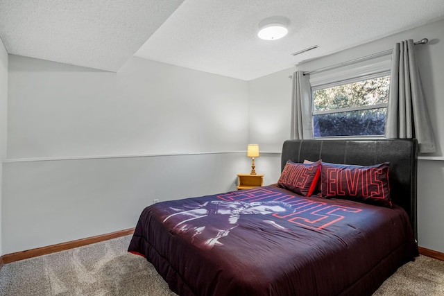 bedroom with carpet floors and a textured ceiling