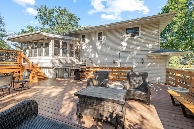 wooden deck featuring a sunroom and a grill