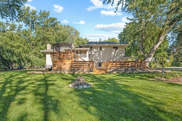 back of house featuring a wooden deck and a lawn