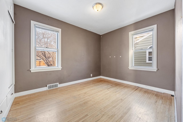 empty room featuring a healthy amount of sunlight and light wood-type flooring