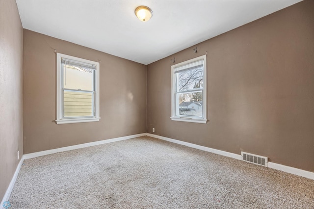 unfurnished room featuring a wealth of natural light and carpet floors