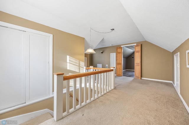 hallway with carpet and vaulted ceiling