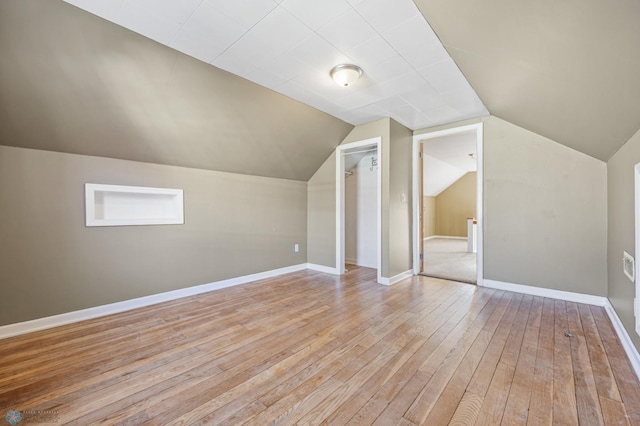 additional living space featuring light hardwood / wood-style floors and lofted ceiling