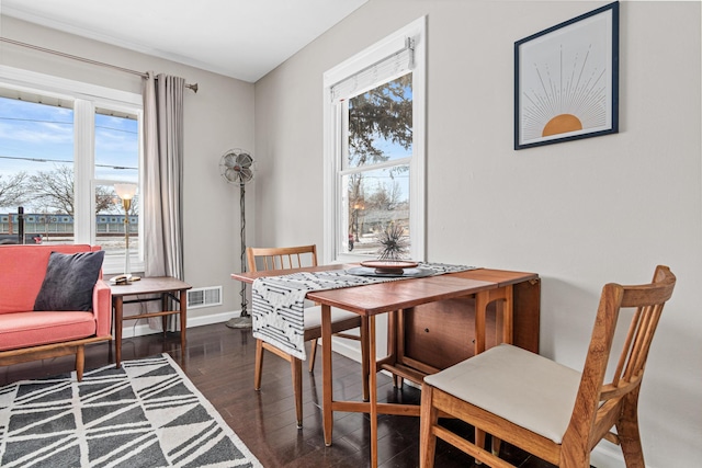 dining space featuring a wealth of natural light and dark hardwood / wood-style flooring