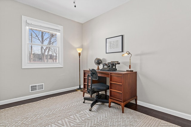 home office with light hardwood / wood-style flooring