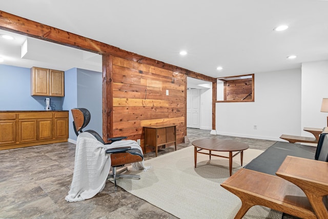 living room with beamed ceiling and wood walls