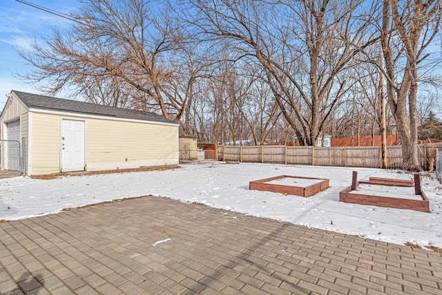 yard covered in snow featuring an outbuilding and a garage