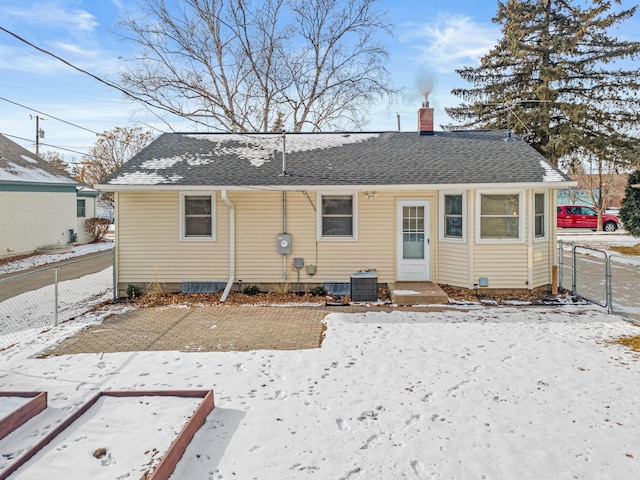 snow covered back of property featuring central AC