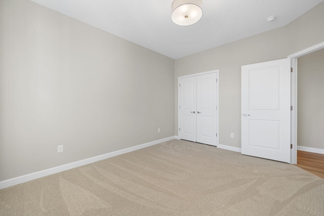 unfurnished bedroom featuring a closet and light carpet