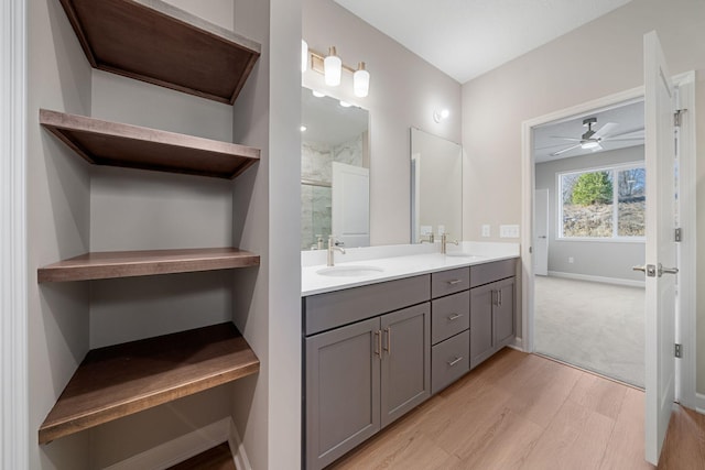 bathroom with a shower with door, wood-type flooring, vanity, and ceiling fan