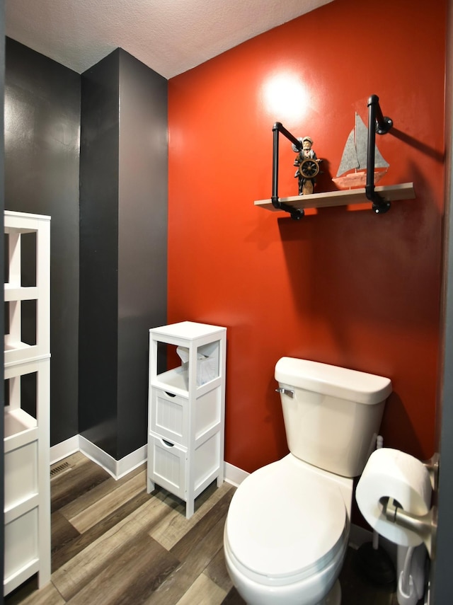 bathroom featuring wood-type flooring and toilet