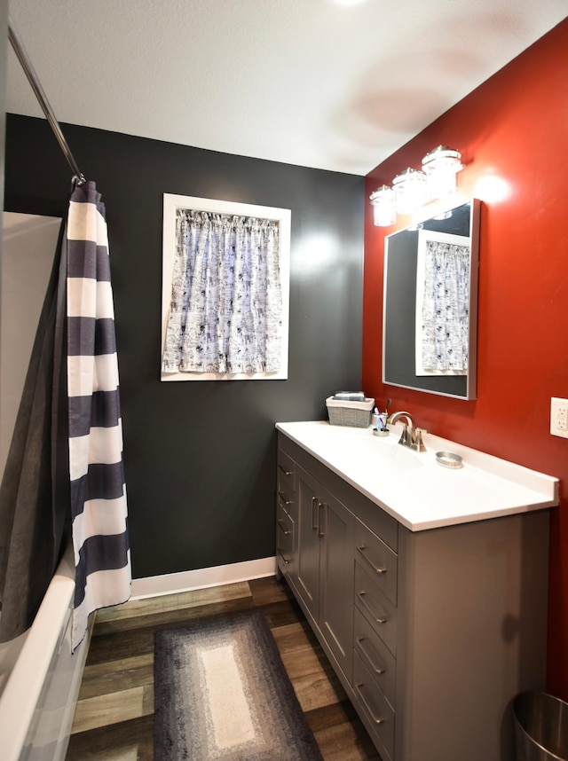 bathroom with vanity, wood-type flooring, and shower / bath combo with shower curtain