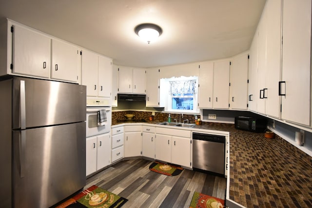 kitchen featuring dark wood-type flooring, stainless steel appliances, sink, and white cabinets