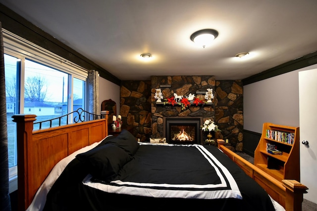 bedroom featuring a stone fireplace