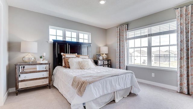 bedroom featuring light carpet and multiple windows