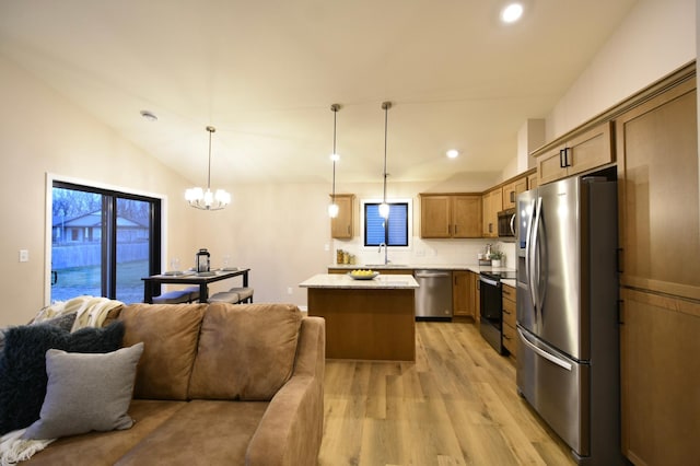 kitchen featuring backsplash, a center island, pendant lighting, sink, and appliances with stainless steel finishes