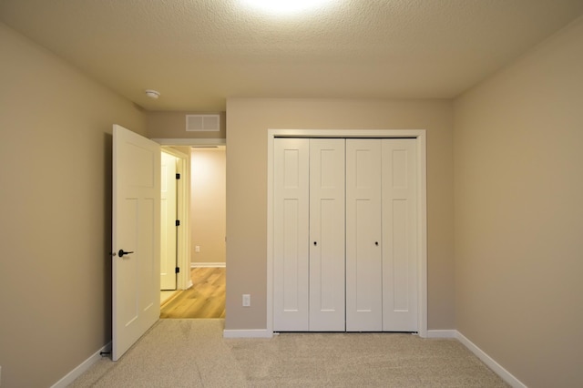 unfurnished bedroom featuring a textured ceiling and a closet