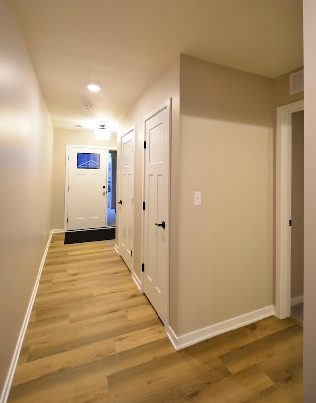 hallway with light hardwood / wood-style flooring