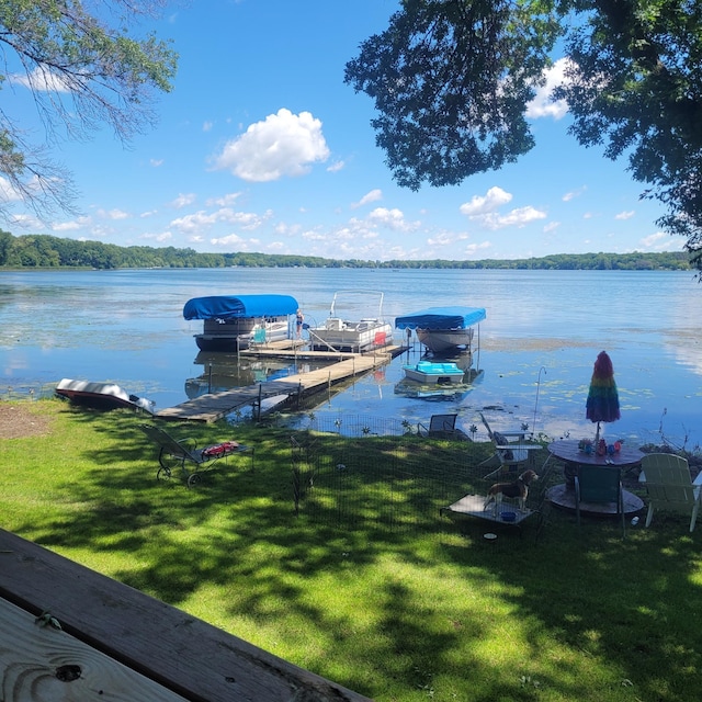 dock area with a lawn and a water view