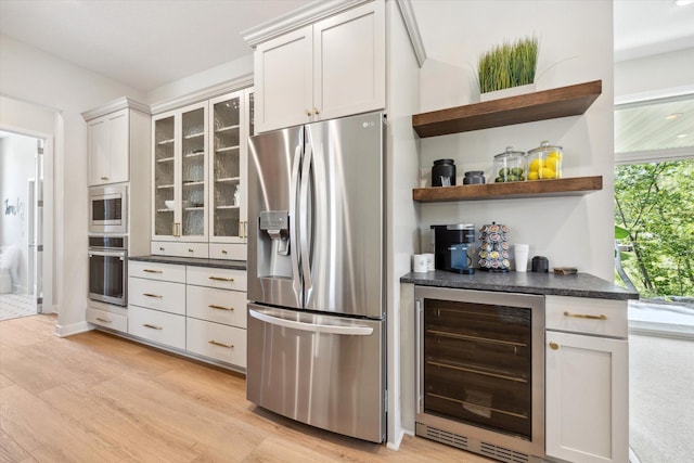 kitchen with wine cooler, light wood-type flooring, white cabinetry, and appliances with stainless steel finishes