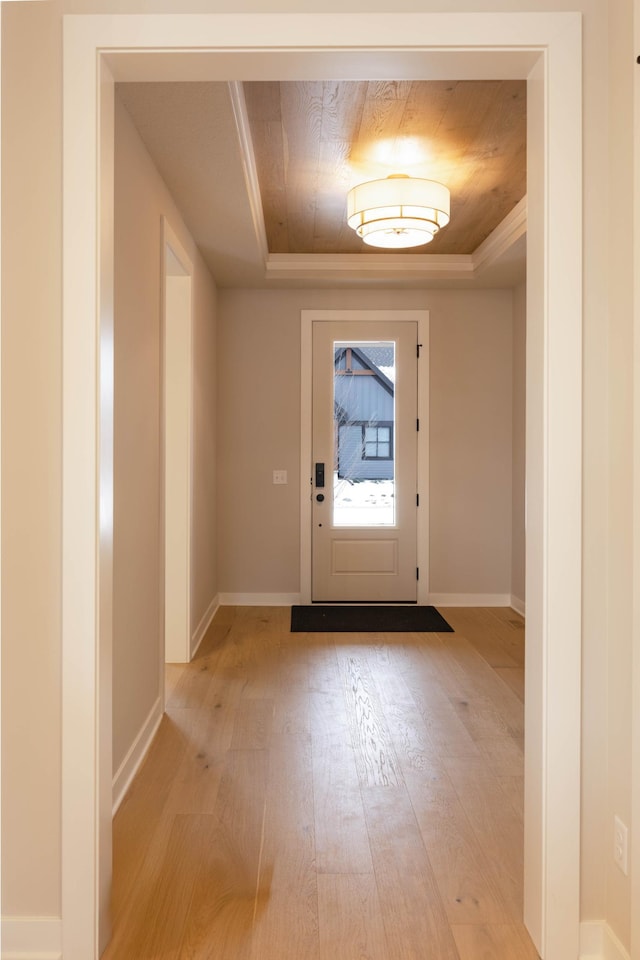 doorway featuring a raised ceiling and light hardwood / wood-style floors